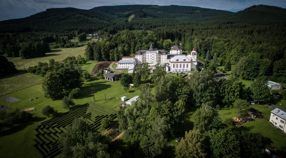 Letecký pohled na areál Sanatoria EDEL v zalesněné krajině